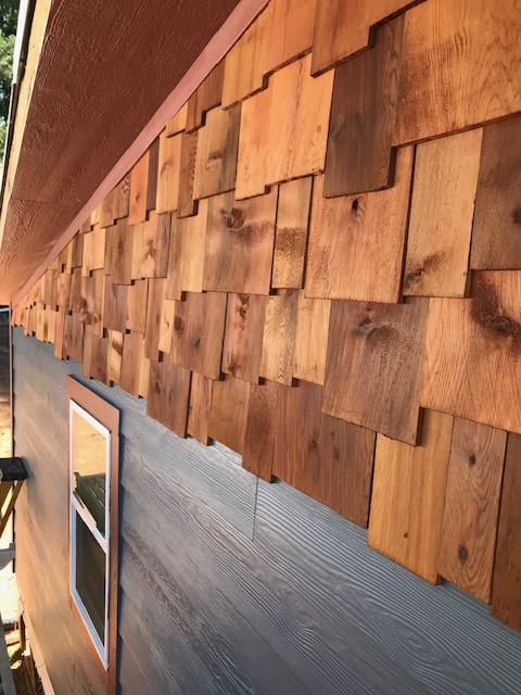 Close-up of hand crafted cedar siding with natural wood grain detail on Oregon home