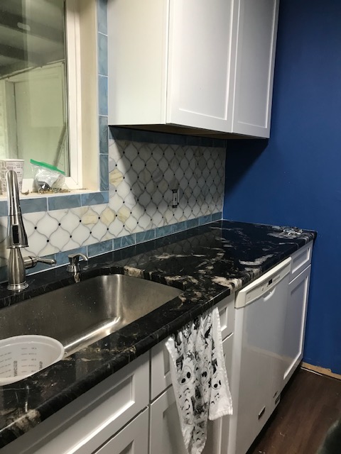 Renovated Oregon kitchen with luxury countertops, tile backsplash and fresh cabinets.